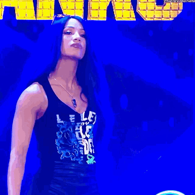 a woman in a black tank top is holding a microphone and wearing a crown