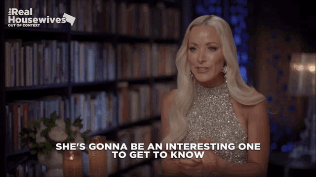 a woman says she 's gonna be an interesting one to get to know in front of a bookcase