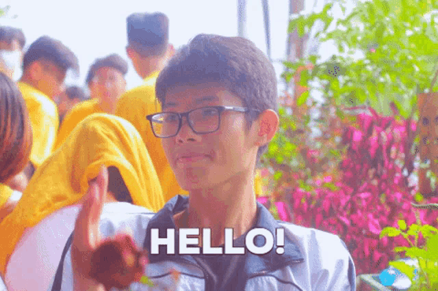 a boy wearing glasses and a jacket says hello
