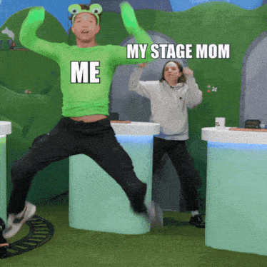 a man in a green frog headband is jumping in the air with the words " my stage mom " above him