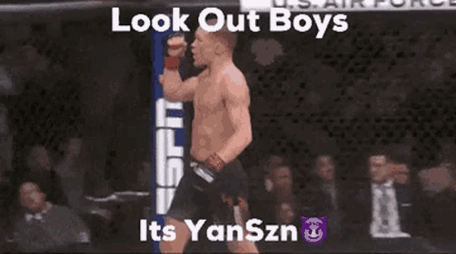 a man without a shirt is standing in a cage with his fist in the air and the words look out boys its yanszn
