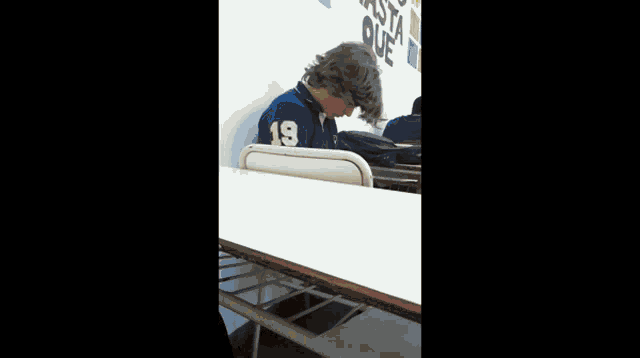 a boy wearing a blue shirt with the number 19 on it