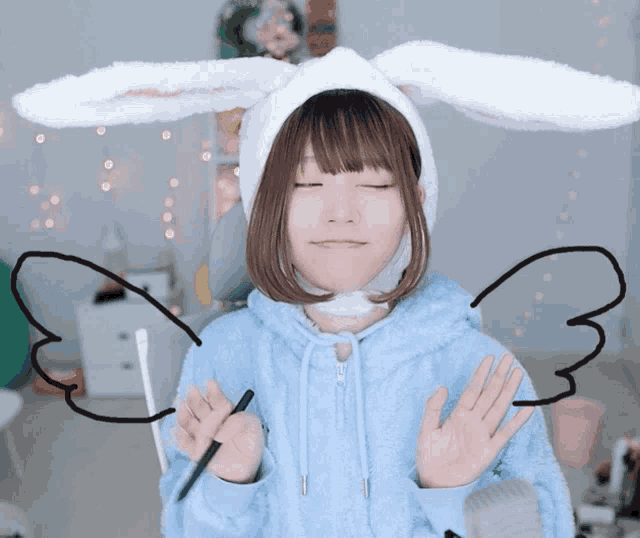a girl wearing bunny ears and a blue hoodie