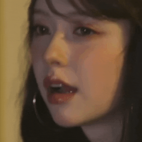 a close up of a woman 's face with her eyes closed and earrings .