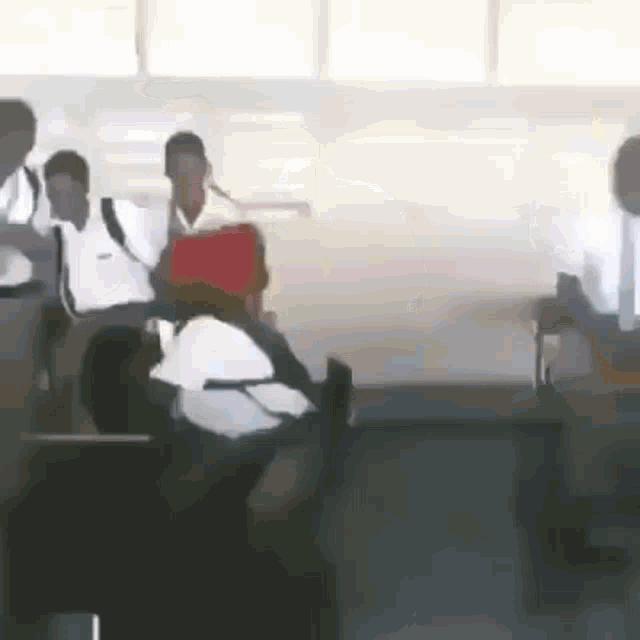 a group of students are sitting in a classroom .