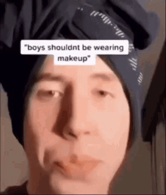 a man wearing a bandana on his head is making a funny face while wearing makeup .