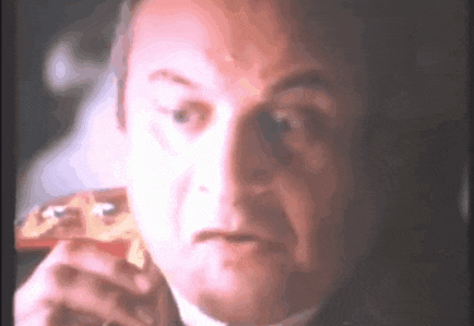 a man in a suit is eating a piece of pizza .