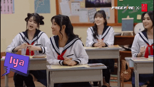 a group of girls are sitting at desks in a classroom and one of them has the name lya on it