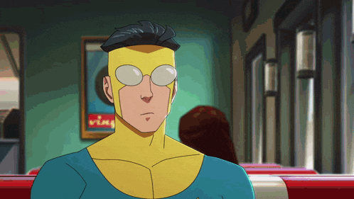 a man in a superhero costume with glasses is sitting in front of a sign that says vim