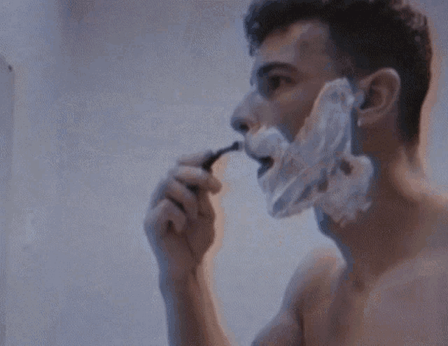 a man brushing his teeth in a bathroom sink