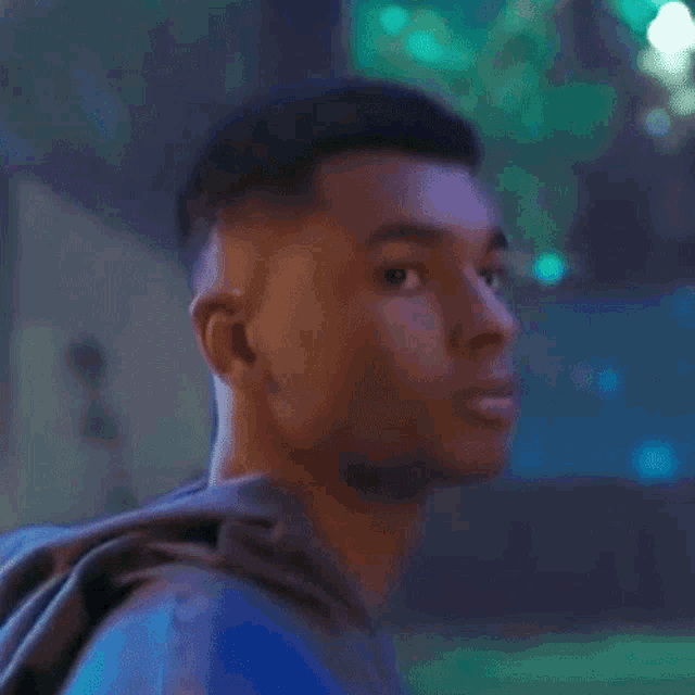a close up of a young man 's face with a blue background