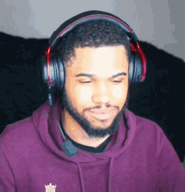 a man wearing headphones and a purple hoodie with a crown on the sleeve