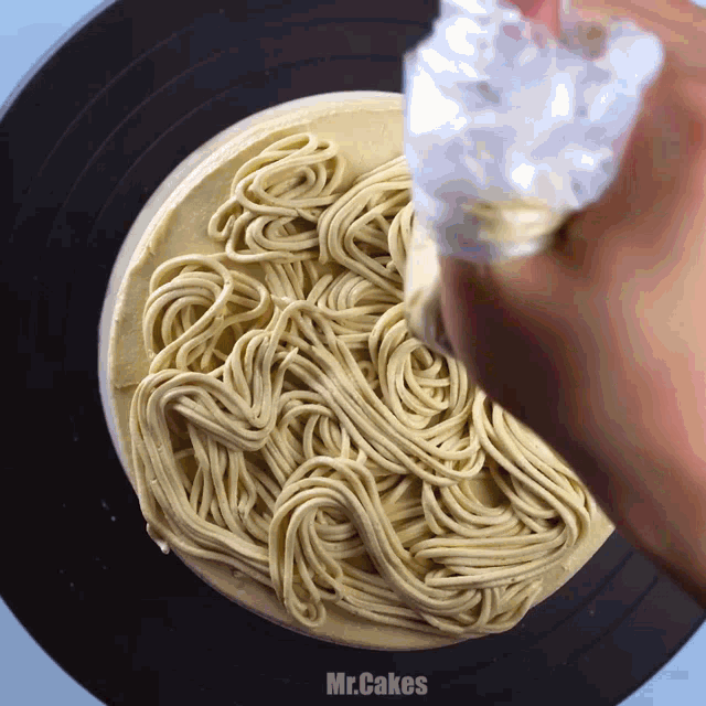 a person is making a cake that looks like noodles and the words mr.cakes are on the bottom