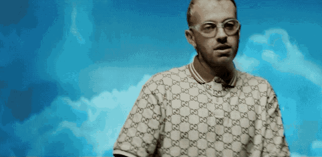 a man wearing glasses and a gucci polo shirt