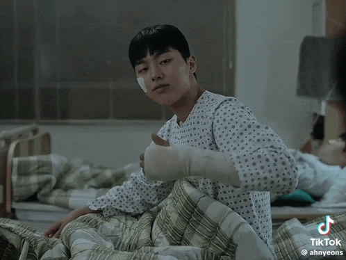 a man in a hospital gown with a bandage on his arm is laying in bed