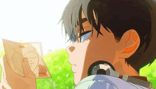 a boy is holding a piece of paper that says " i love you " on it