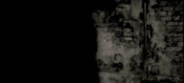 a group of people are standing next to each other in a dark room .