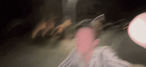 a blurry picture of a person holding a balloon in a dark room at night .