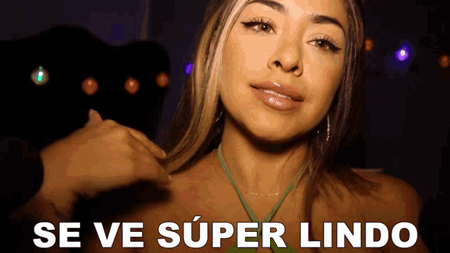 a woman in a green top is being touched by a man and the words se ve super lindo are written below her