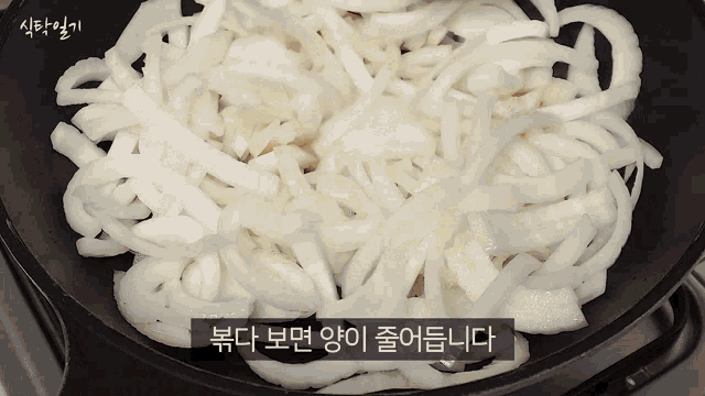 noodles are being cooked in a frying pan with korean writing on the bottom right corner