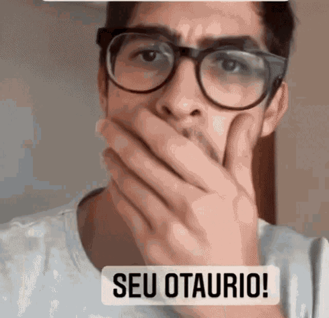 a man wearing glasses is covering his mouth with his hand and the words seu otaurio are above him