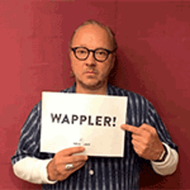 a man wearing glasses is holding a sign that says wappler .
