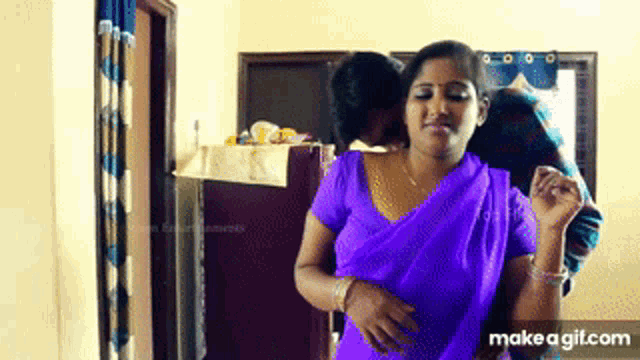 a woman in a purple saree is dancing with a man