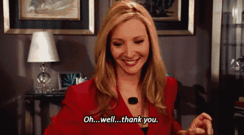 a woman in a red jacket is smiling and saying " oh well thank you "