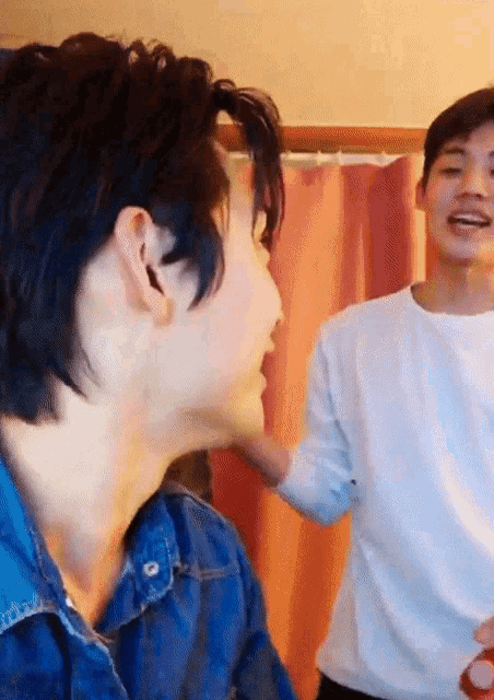 a man in a white shirt is standing next to another man in a blue shirt