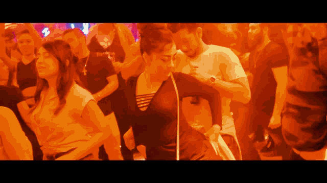 a man in a white shirt with the word puma on it is dancing in a crowd