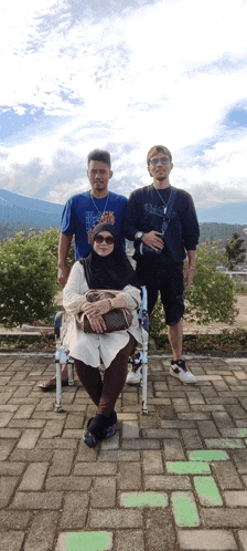 a woman in a wheelchair poses with two other people