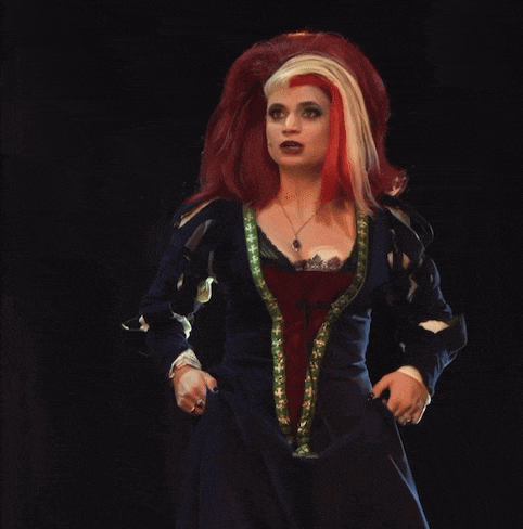 a woman with red hair is wearing a blue dress and a necklace