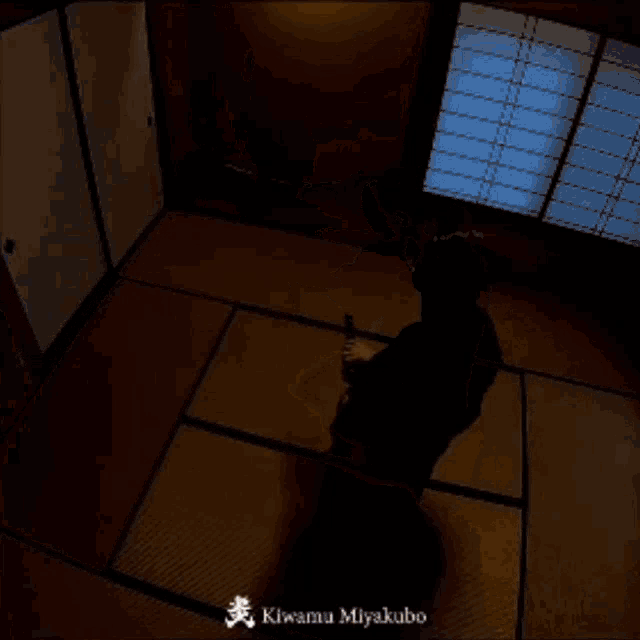 a man is holding a sword in a room with the name kiwamu miyakubo written on the bottom
