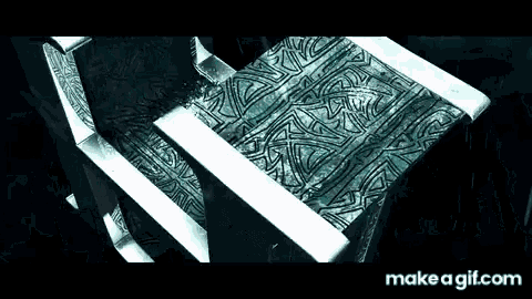 a chair with a pattern on it is sitting on a table in a dark room .