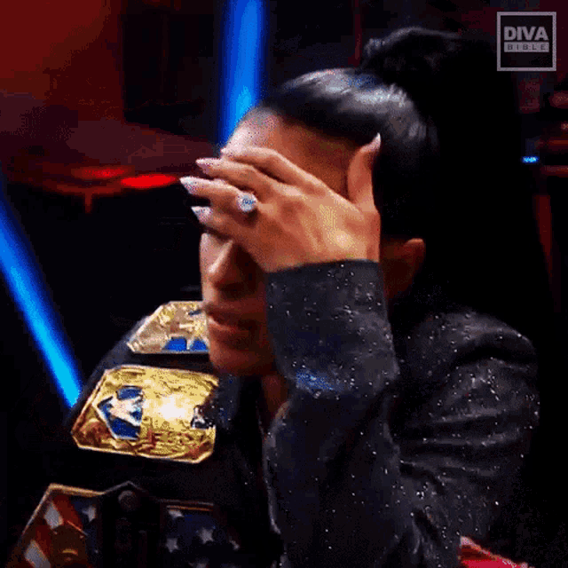 a woman wearing a diva ring holds her hand to her head
