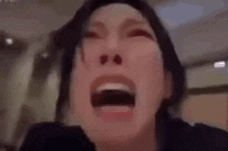 a close up of a woman 's face with her mouth open and her eyes closed .