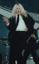 a man in a suit is playing a guitar on stage