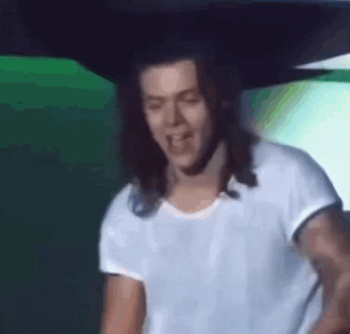 a man with long hair is wearing a white t-shirt .