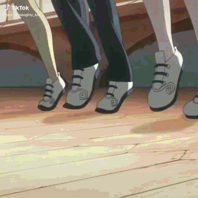 a group of people are standing on a wooden floor wearing white shoes