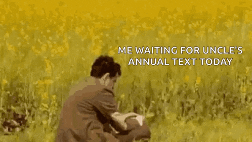 a man in a suit and tie is standing in a field with a laptop .