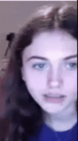 a close up of a girl 's face with a blue shirt on .