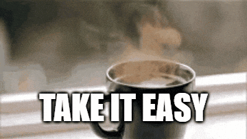 a cup of coffee with steam coming out of it and the words take it easy below it .