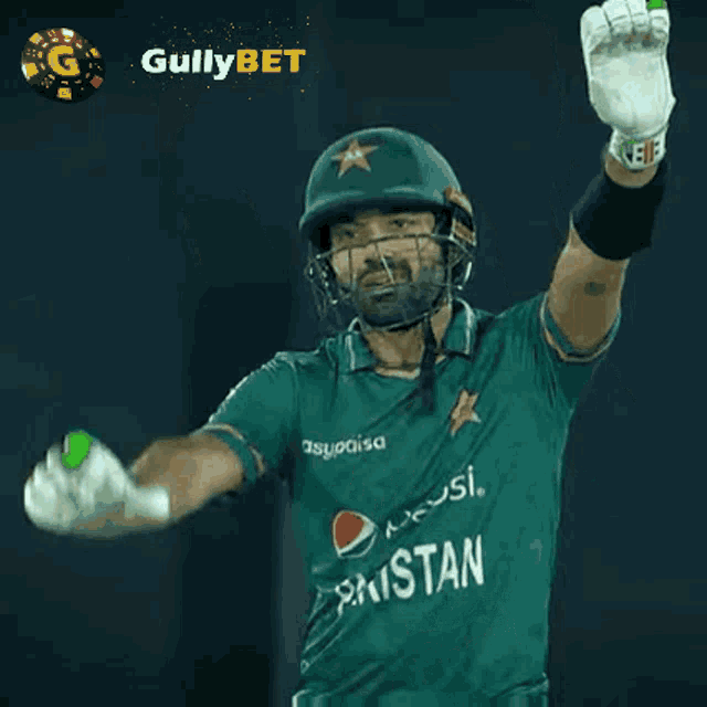 a cricket player wearing a pepsi shirt holds his arms up in the air