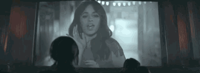 a group of people are watching a movie on a screen .