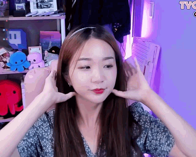 a woman 's face is shown in front of a purple background with the letters tyc on it