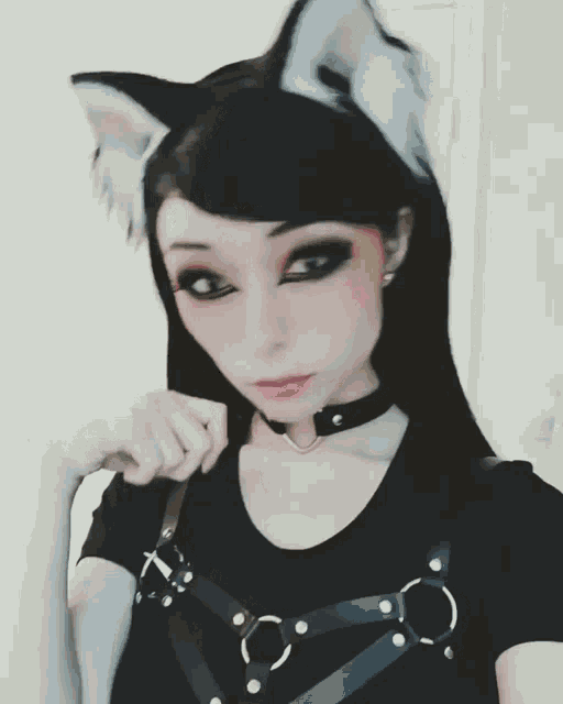 a girl with black hair and cat ears is wearing a choker