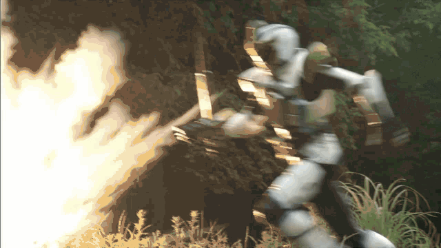 a robot with a bow and arrow is holding a sword in front of a fire