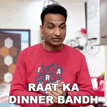 a man wearing a red sweater says " raat ka dinner bandh "