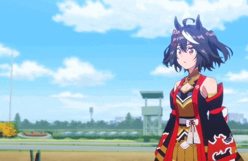 a girl in a red and gold outfit is standing in front of a race track