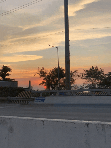 a sunset over a highway with a sign that says emergency exit